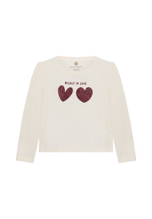 Crèmekleurig kinderhemd met lange mouwen, twee rode glitterharten en tekst "WILDLY IN LOVE" aan de voorkant. Maatlabel 104 zichtbaar aan de binnenkant van de kraag.