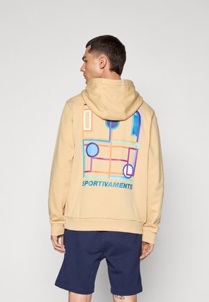 Beige hoodie med et grafisk design på ryggen, der viser farverige abstrakte former og ordet "SPORTIVAMENTE" i blåt.