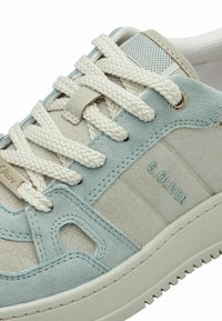Zapatillas de ante azul claro y crema texturizada con cordones de crema trenzados, detalle de logo y acentos perforados en la lengua y el lateral.