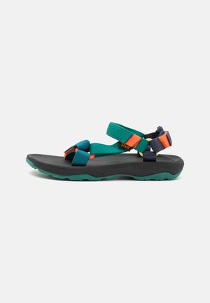 Teva-sandalen met groene en marineblauwe bandjes, oranje accenten en een zwarte rubberen zool. Voorzien van verstelbare bandjes voor een veilige pasvorm.