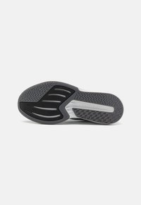 Semelle de chaussure en caoutchouc noir avec un motif texturé, présentant des rainures pour la prise et le mot "LIGHTSTRIKE" embossé sur le côté.