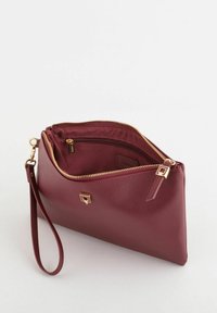 Clutchtaske i bordeaux med guldfarvet hardware, tekstureret materiale og lynlåslukning. Har håndledsrem og indvendig lynlåslomme.