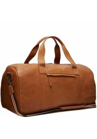 Bolsa de viaje de cuero marrón con textura suave, asas superiores, correa de hombro desmontable y cierre de cremallera con detalle en el bolsillo frontal.