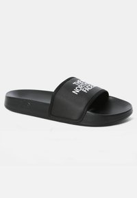 Black slide sandals with a textured synthetic strap featuring white brand text. Flat sole with a smooth finish and subtle branding detail.