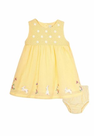 Ærmeløs gul babykjole med broderede hvide kaniner og blomster, kombineret med gule og hvide stribede bloomers.