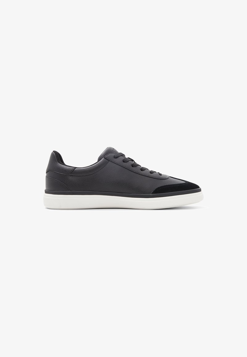 Zapatillas negras con parte superior de cuero, acentos de ante, suela de goma blanca, diseño de cordones y puntera redondeada para un estilo casual.