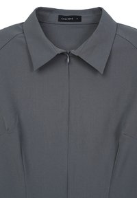 Blusa grigia con colletto, texture liscia, maniche corte e dettaglio con zip frontale, etichettata con il marchio "CALLIOPE."