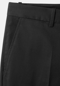 Pantalon noir sur mesure avec poches latérales, passants pour ceinture et une texture de tissu propre et lisse.