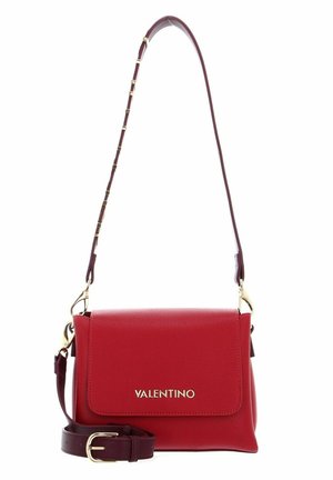 Sac à main en cuir rouge avec une finition texturée, quincaillerie dorée et une bandoulière amovible dotée de petits maillons décoratifs. Le rabat avant présente le logo.