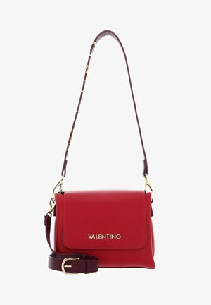 Sac à main en cuir rouge avec une finition texturée, quincaillerie dorée et une bandoulière amovible dotée de petits maillons décoratifs. Le rabat avant présente le logo.