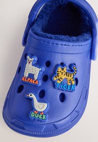 Sinine kummist klots koos kolme värvilise loomateemalise kaunistusega: alpaka, tiiger ja part. Pehme ja karvane vooder sees mugavuse tagamiseks.