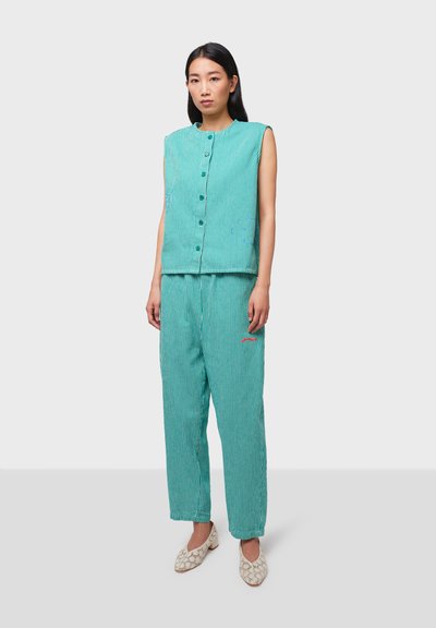Turquoise striped sleeveless top with a round neckline and button closure, paired with matching loose-fitting striped trousers.