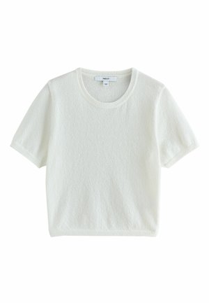 Haut en maille douce blanc à manches courtes avec encolure ronde et ourlet court, étiqueté par la marque "NEXT."