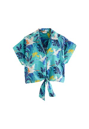Crop top turquoise à manches courtes avec un lien à l'avant, avec un motif de feuilles tropicales bleues et jaunes et des grues blanches en vol.