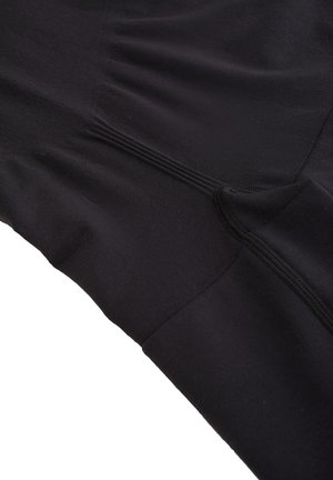 Zwart sporttop gemaakt van een gladde stof, met een aansluitend ontwerp, getextureerde naden en subtiele plooidetails langs de zijkant.