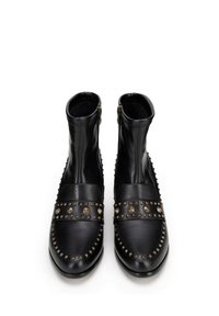Czarne skórzane botki za kostkę z ćwiekami, o zaokrąglonym nosie i bocznymi zamkami błyskawicznymi. Posiadają gładkie wykończenie i teksturowane detale po bokach.