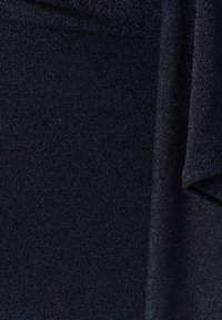 Ciemnoniebieska, teksturowana tkanina o subtelnym połysku. Posiada delikatne prążkowanie oraz miękkie, gładkie wykończenie, co tworzy elegancki, jednolity wygląd.