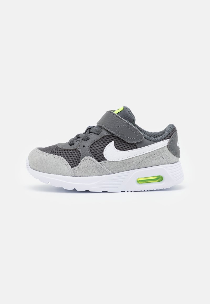 Grå idrottssko med övre del i mesh och mocka, vita accenter och ett grönt luftfick. Utrustad med en kardborreband och snörning.