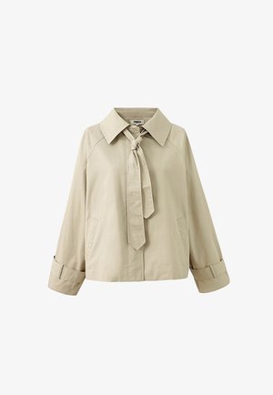 Veste courte beige avec col large, manches longues avec lanières aux poignets, poches latérales et détail à nouer à l'avant au niveau du cou.