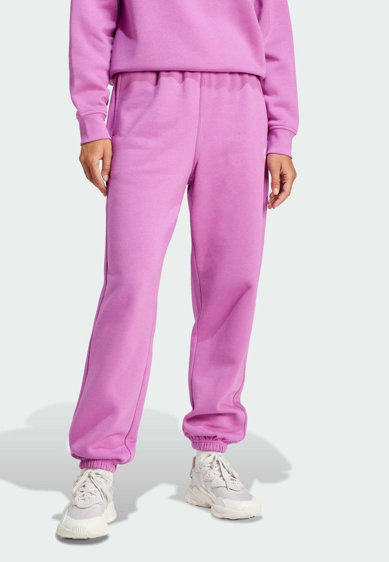 Rosa sweatpants gjorda av mjukt tyg, med elastisk midjeband och manschetter, i avslappnad passform och sidofickor. Matchas med ljusa sneakers.