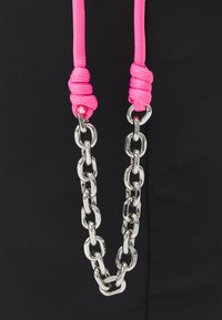 Sac noir avec des cordons en nylon rose vif noués en haut et une poignée en chaîne argentée avec des maillons ovales.