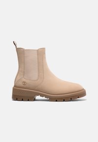 Bottine Chelsea en cuir beige avec panneaux latéraux élastiques, languette à l'arrière et semelle épaisse à crampons en caoutchouc marron clair.