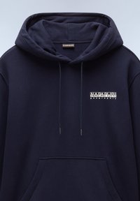 Marinblå bomullshuvtröja med framficka, dragsnören och vit logotext på vänster bröst. Slät textur, avslappnad design.