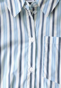 Light blue and white striped shirt with a pointed collar, front buttons, and a small chest pocket. Fabric appears smooth and lightweight.