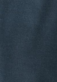 Tamno plavi materijal s glatkom teksturom i suptilnim meliranjem, s uniformnim tkanjem i blago mekanim završetkom.