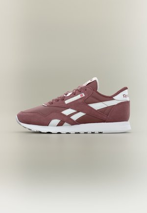 Baskets Reebok bordeaux et blanches avec dessus en daim et mesh, semelle blanche et logo de la marque sur le côté et le talon, vues de profil sur fond uni.