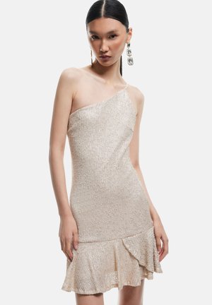 Robe beige à une épaule ornée de perles, avec un ourlet évasé, présentant une surface texturée et une silhouette cintrée.
