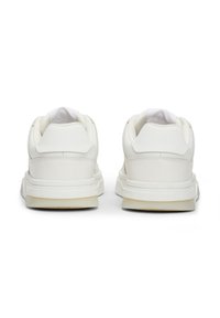 Sneakers bianchi in pelle con colletto imbottito, retro testurizzato e design minimalista. Presentano una suola in gomma sottile con una tonalità chiara.