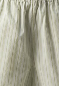 Lightweight cotton shorts with a gathered elastic waistband. Features vertical stripes in green on a white background. Soft texture.
