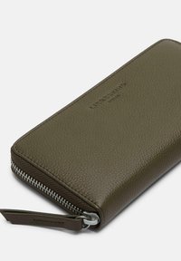Portfel ze skóry w oliwkowym zielonym kolorze, o fakturowanej powierzchni, z zamknięciem na zamek błyskawiczny i srebrnym okuciem zamka. Z ozdobnym tłoczonym logo marki.