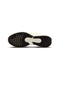 Suola di una scarpa sportiva bianca con battistrada in gomma nera texturizzata e una sezione di cuscino d'aria visibile nell'area del piede medio.