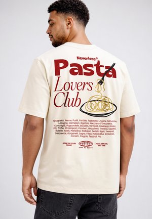 Mann trägt ein cremefarbenes T-Shirt mit rotem Text "Pasta Lovers Club" und einer Grafik von Spaghetti mit Gabel auf dem Rücken.