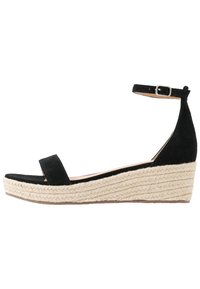 Black suede wedge sandal with a wide toe strap, ankle strap with buckle, and a textured jute-wrapped heel.