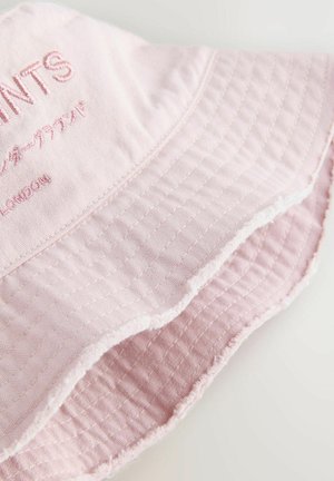 Hele roosa värvi kausskübar tekstuurse kangaga, millel on tikitud mustrid, õmblusdetailid ja esiküljel tikitud kiri.