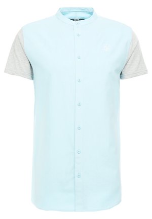 Camicia a maniche corte con corpo azzurro chiaro e maniche in tessuto grigio, dotata di chiusura con bottoni e un piccolo logo ricamato.