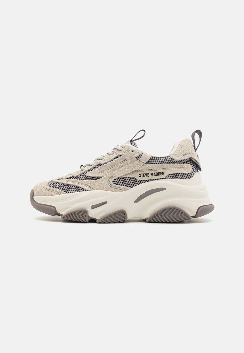 Beige sneakers with a mesh and suede upper, featuring gray accents. Thick white midsole and textured rubber outsole. Laced closure with a pull tab.