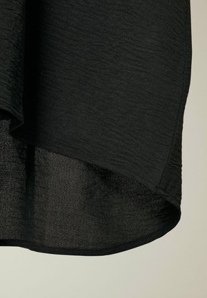 Sort tekstureret stof med et subtilekrøllet design. Kanten er buet, hvilket viser et uigennemsigtigt indre lag og en glat ydre finish.