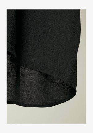 Sort tekstureret stof med et subtilekrøllet design. Kanten er buet, hvilket viser et uigennemsigtigt indre lag og en glat ydre finish.