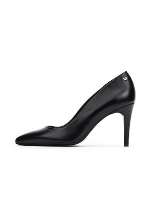 Zapato de tacón alto de cuero negro con punta afilada y textura suave. Presenta un sutil logo dorado en el tacón y un diseño de tacón stiletto delgado.