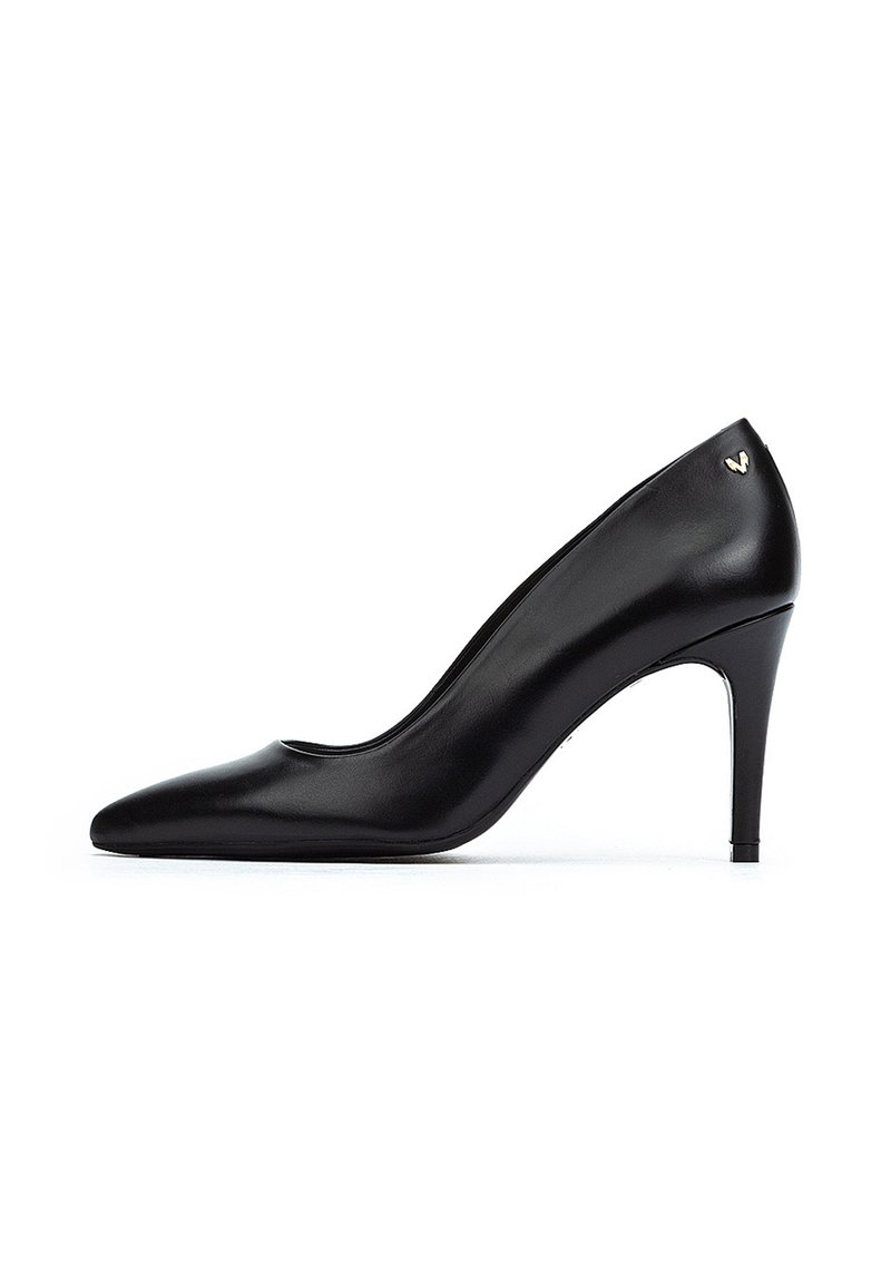 Zapato de tacón alto de cuero negro con punta afilada y textura suave. Presenta un sutil logo dorado en el tacón y un diseño de tacón stiletto delgado.