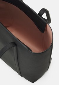 Black textured handbag with a smooth pink lining, featuring a zip closure and two short handles. Rectangular shape, minimalist design.