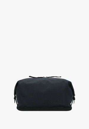 Zwarte rechthoekige zachte reistas met dubbele ritssluitingen en subtiel "Thule" logo aan de voorkant.