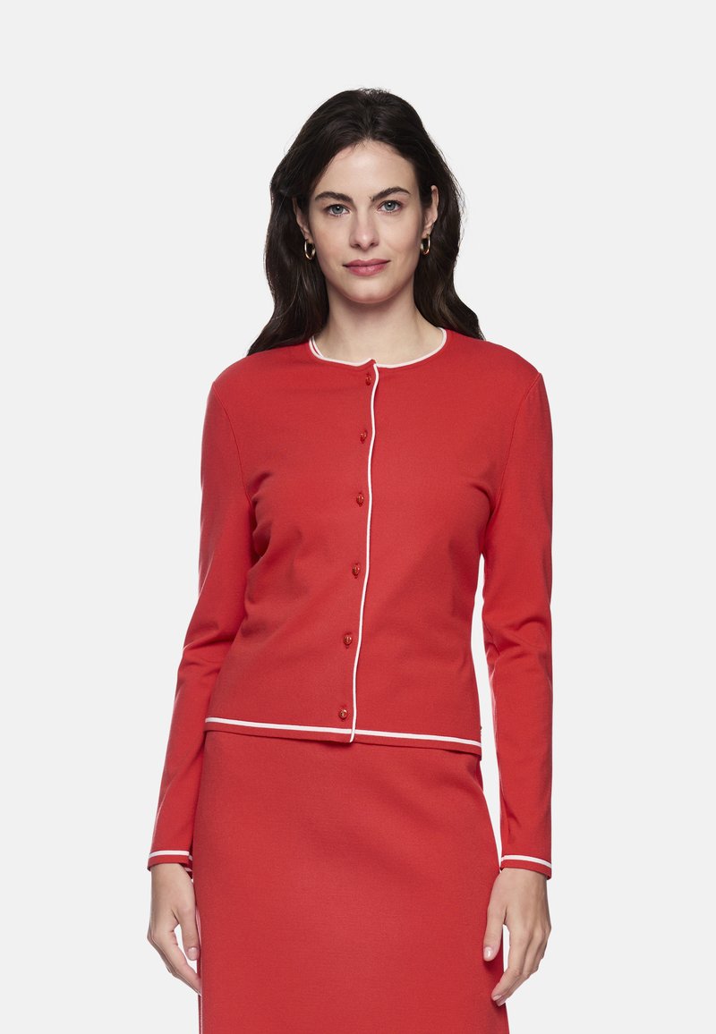 Red knit cardigan with long sleeves, round neckline, and white piping along the edges. Features small buttons down the front.