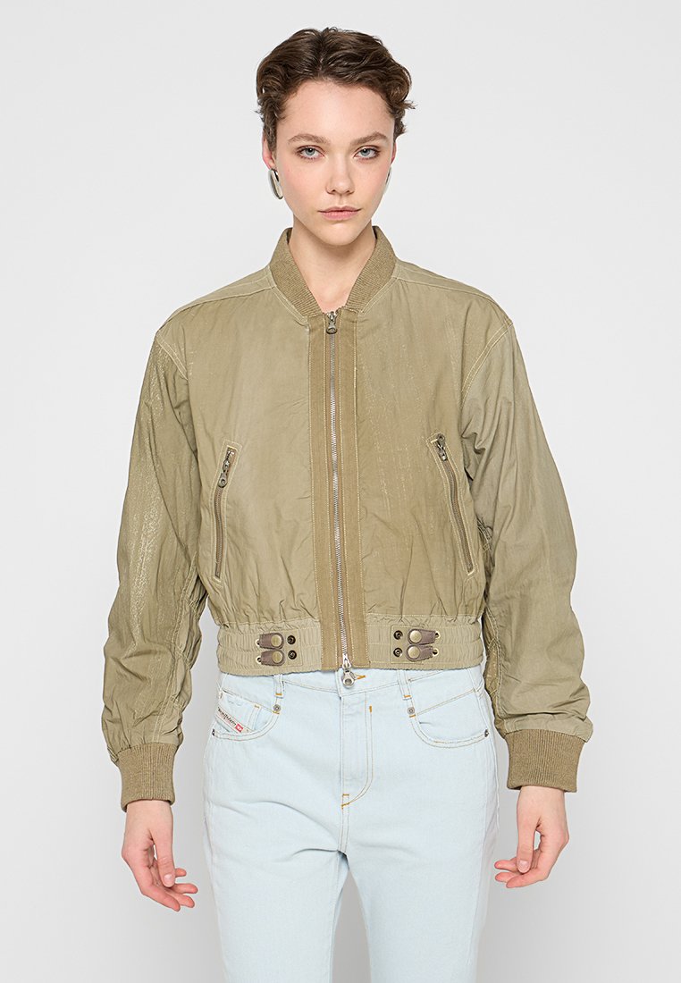 Olivgrüner Bomberjacke mit Reißverschluss vorne, gerippten Bündchen, seitlichen Reißverschlusstaschen und cropped Design. Texturiertes Material mit subtiler Glanz.