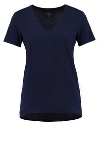 Mörkblå v-ringad t-shirt i mjuk bomull med korta ärmar och en rundad fåll. Har en liten logotyp på vänster sida.