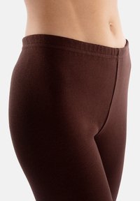 Brązowe leggings prążkowane z wysokim stanem i obcisłym krojem, wykonane z elastycznego materiału zapewniającego komfort i swobodę ruchów.